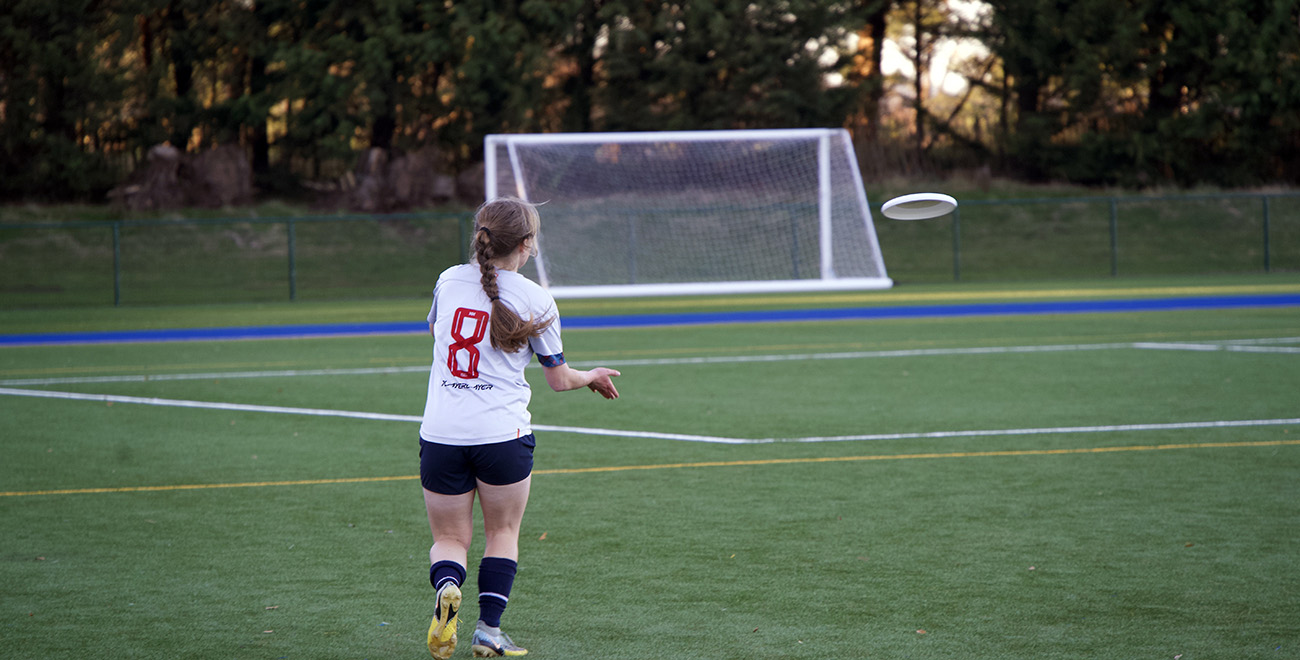 Students playing a casual game of frisbee on grass