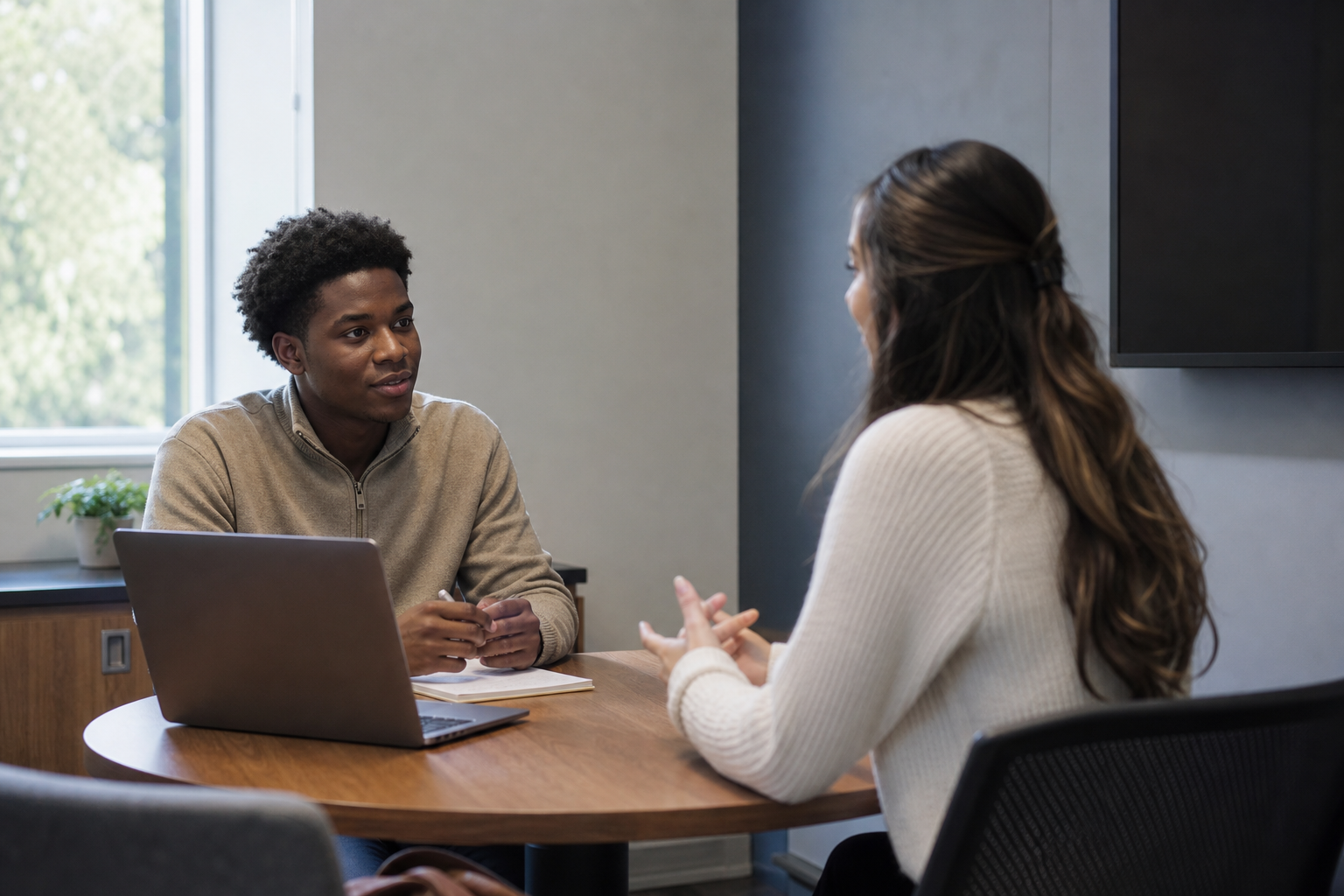 Two students practicing an interview in a campus meeting room