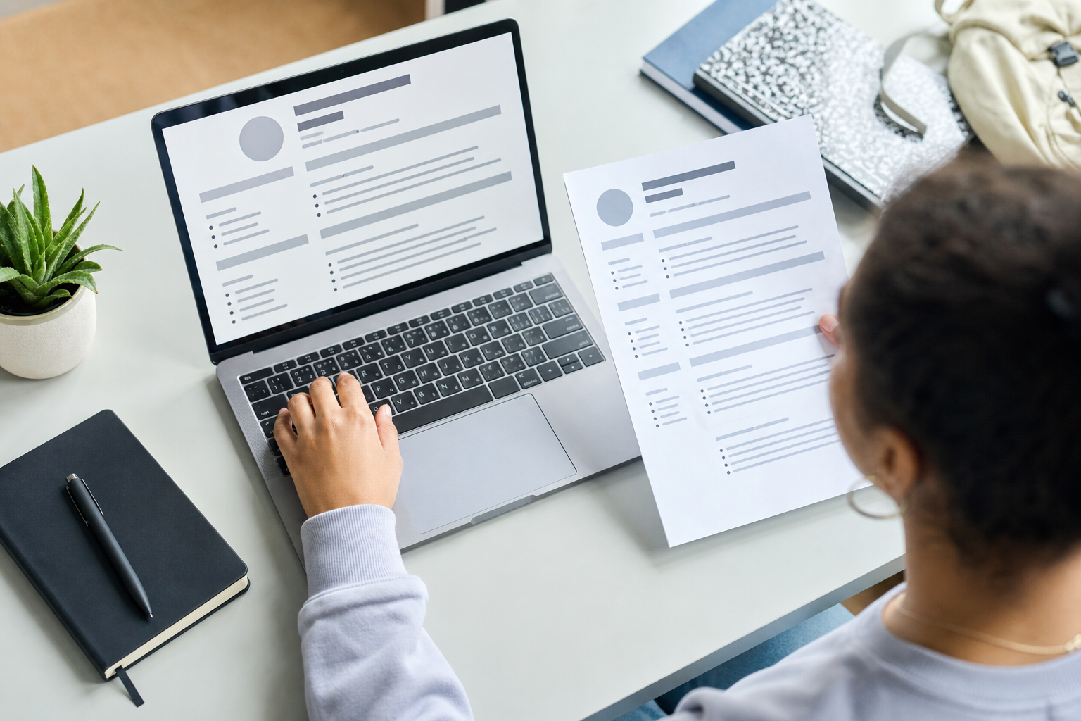 Clean student résumé being checked on a laptop and printed page